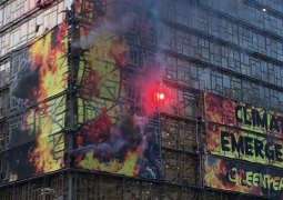 Climate Activists Climb, Set Off Flares on EU Building Before Crucial Summit