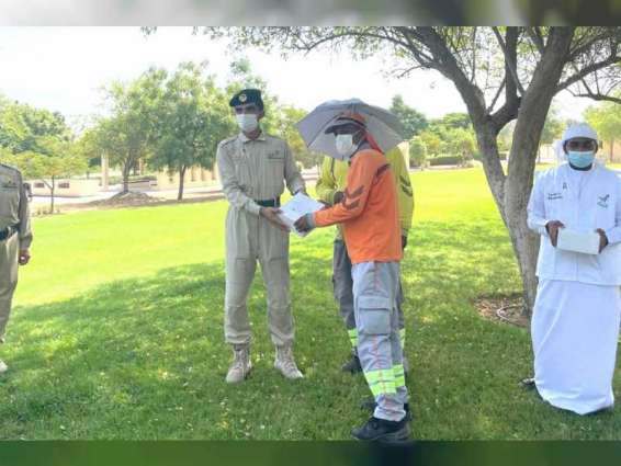 Dubai Police, Spirit of the Union Volunteers distribute meals, 100 umbrella hats to workers