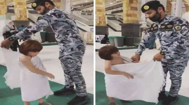 شاھد مقطع : رجل الأمن السعودي یساعد طفلا لارتداء ملابس الاحرام
