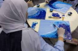 Children ride the waves of creativity in a painting workshop 
