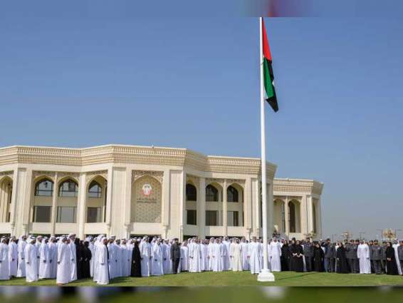 خالد بن محمد بن زايد يرفع علم الدولة أمام مبنى ديوان ولي العهد احتفاءً بيوم العلم